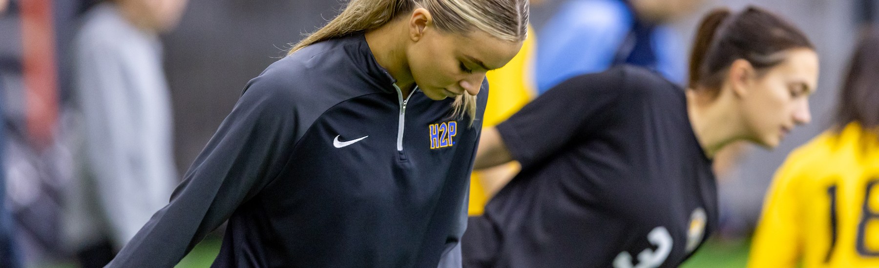 Ava Boyd, a Pitt soccer player and member of the Riveters' inaugural 2025 team, stretches before the Riveters' open combine last December at the AHN Montour Sports Complex. (Photo: Mallory Neil/Riveters SC)