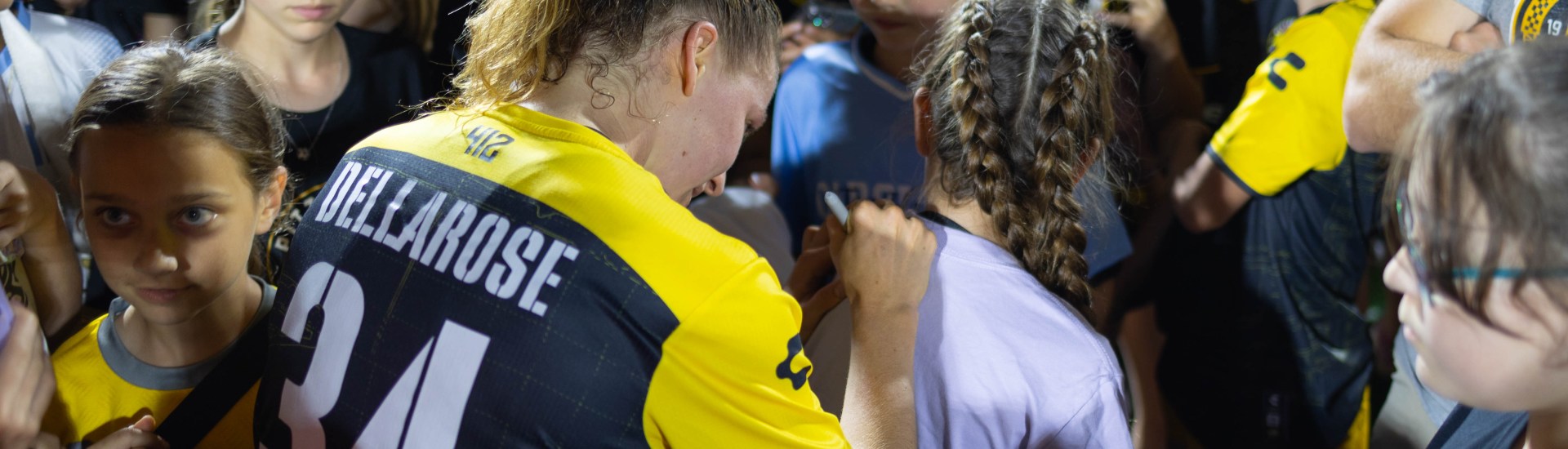 Pittsburgh Riveters midfielder Tessa Dellarose signs a young fan's shirt during the team's post-match autograph session after their opening match, May 16, 2025, at Highmark Stadium. (Photo: John Sykes/Riveters SC)
