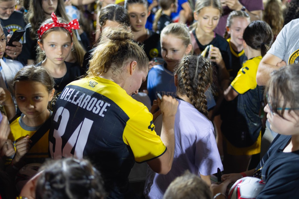 Pittsburgh Riveters midfielder Tessa Dellarose signs a young fan's shirt during the team's post-match autograph session after their opening match, May 16, 2025, at Highmark Stadium. (Photo: John Sykes/Riveters SC)