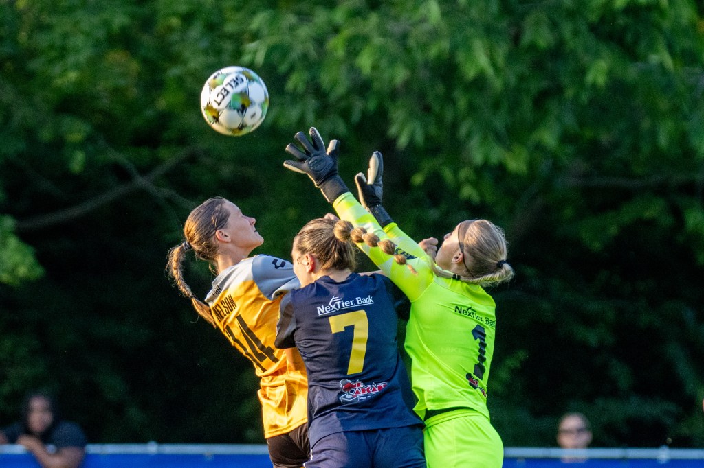 Pittsburgh Riveters midfielder Tanum Nelson jumps to challenge for the ball against Steel City FC's Claire Dorfman and goalkeeper Payton O'Malley. The Riveters won the match, 3-1, on June 11, 2025 at Founders Field in Indiana Township, Pa. (Photo: Chris Cowger/Riveters SC)