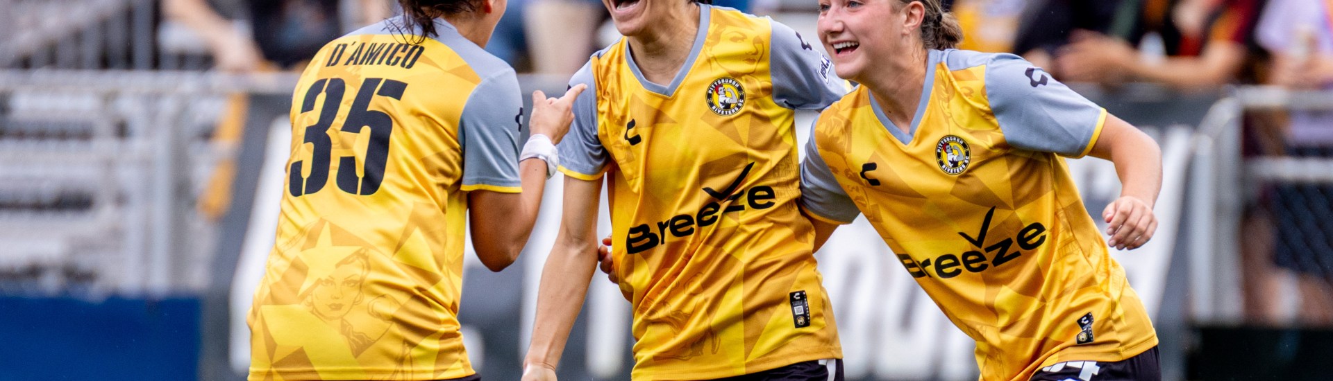 Sabrina Bryan (center) celebrates with teammates Olivia Damico and Anna Korney after scoring the opening goal of the Pittsburgh Riveters' 7-0 win over Erie Sports Center on June 15, 2025 at Highmark Stadium in Pittsburgh. (Photo: Chris Cowger/Riveters SC)