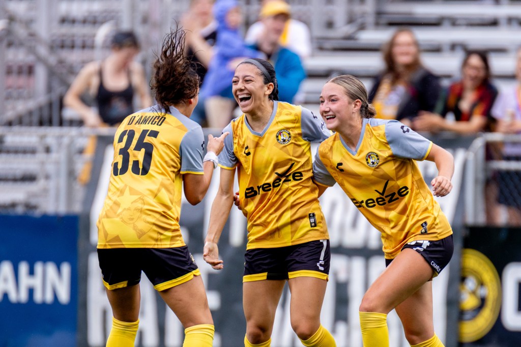 Sabrina Bryan (center) celebrates with teammates Olivia Damico and Anna Korney after scoring the opening goal of the Pittsburgh Riveters' 7-0 win over Erie Sports Center on June 15, 2025 at Highmark Stadium in Pittsburgh. (Photo: Chris Cowger/Riveters SC)