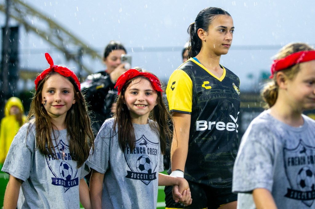 Olivia Damico walks out onto the field joined by young girls players prior to the Pittsburgh Riveters' match against Flower City 1872 on May 30, 2025 at Highmark Stadium in Pittsburgh. (Photo: Chris Cowger/Riveters SC)