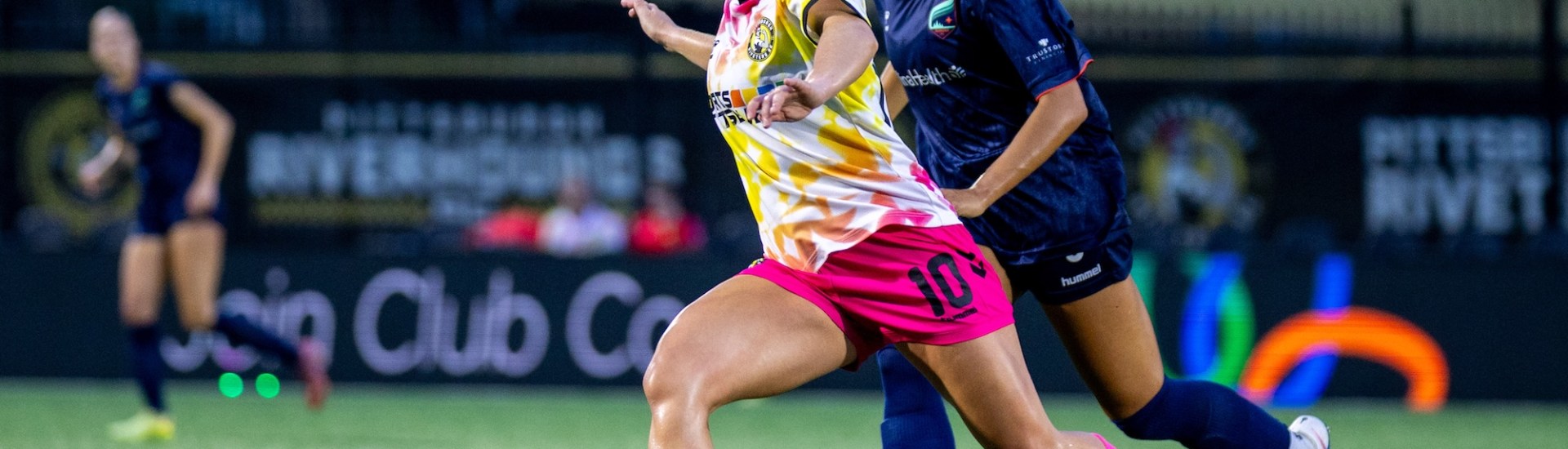 Ellen Molloy strikes a pass with a defender trailing her in the Pittsburgh Riveters playoff match against Minnesota Aurora FC on July 5, 2026 at F.N.B. Stadium in Pittsburgh. (Photo: Chris Cowger/Riveters SC)