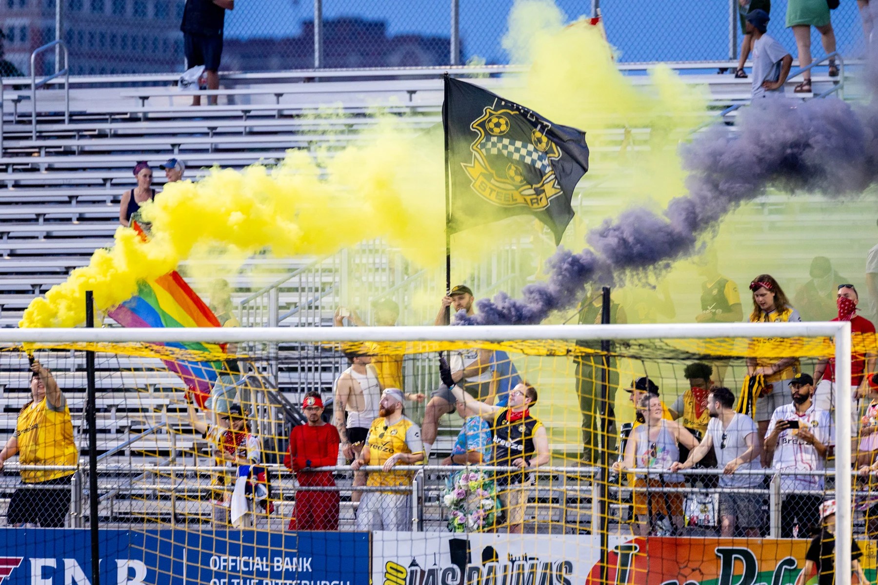 The Steel Army waves flags through black and gold smoke at F.N.B. Stadium