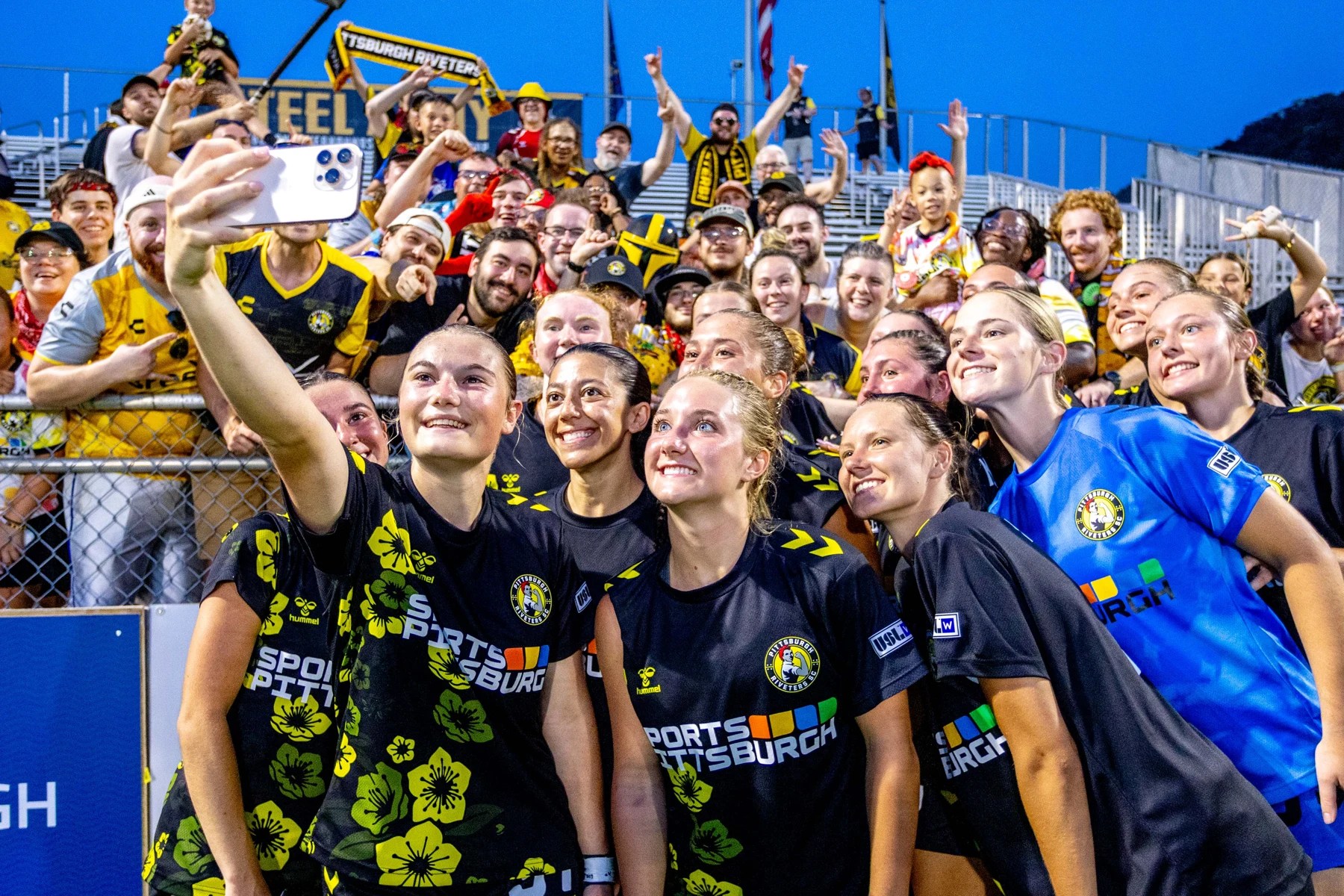 Riveters players celebrate a playoff win with supporters at F.N.B. Stadium